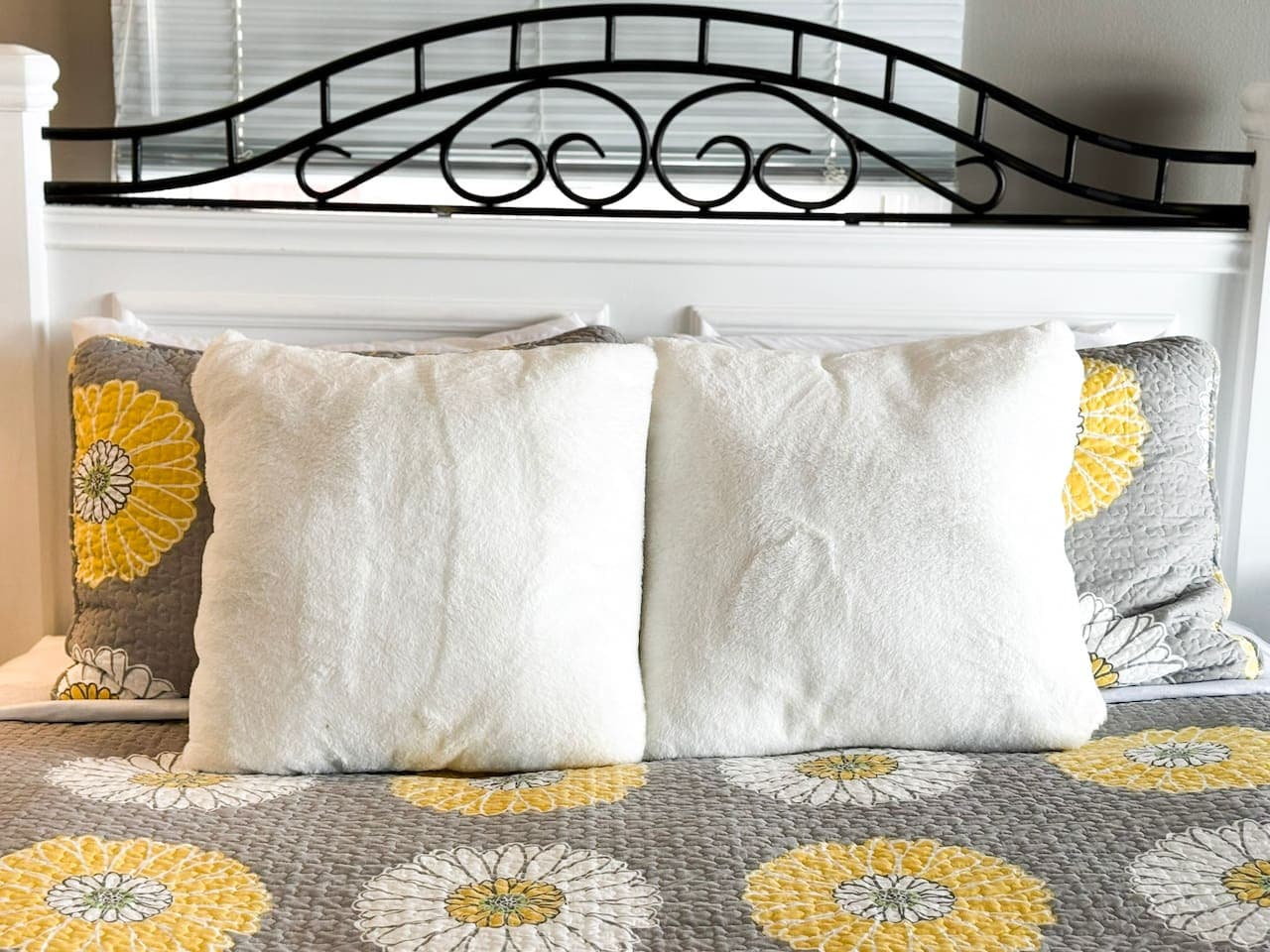 Plush accent pillows on a stylish, floral-themed bed.