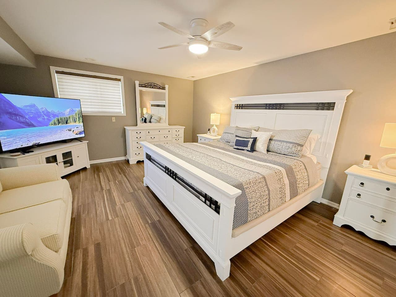 Spacious master suite with king bed, TV, and dresser.