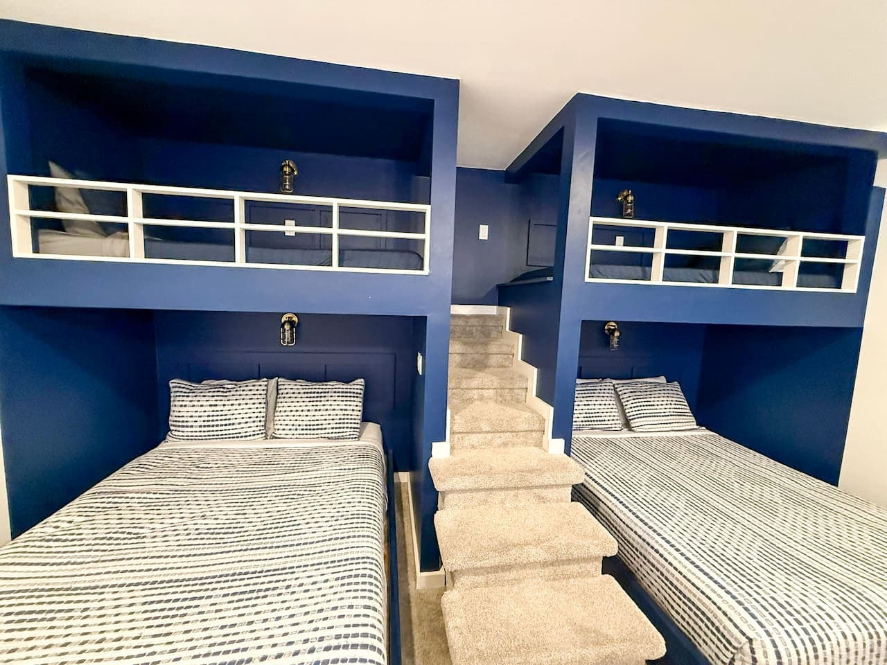 Spacious bunk setup with steps to upper beds.