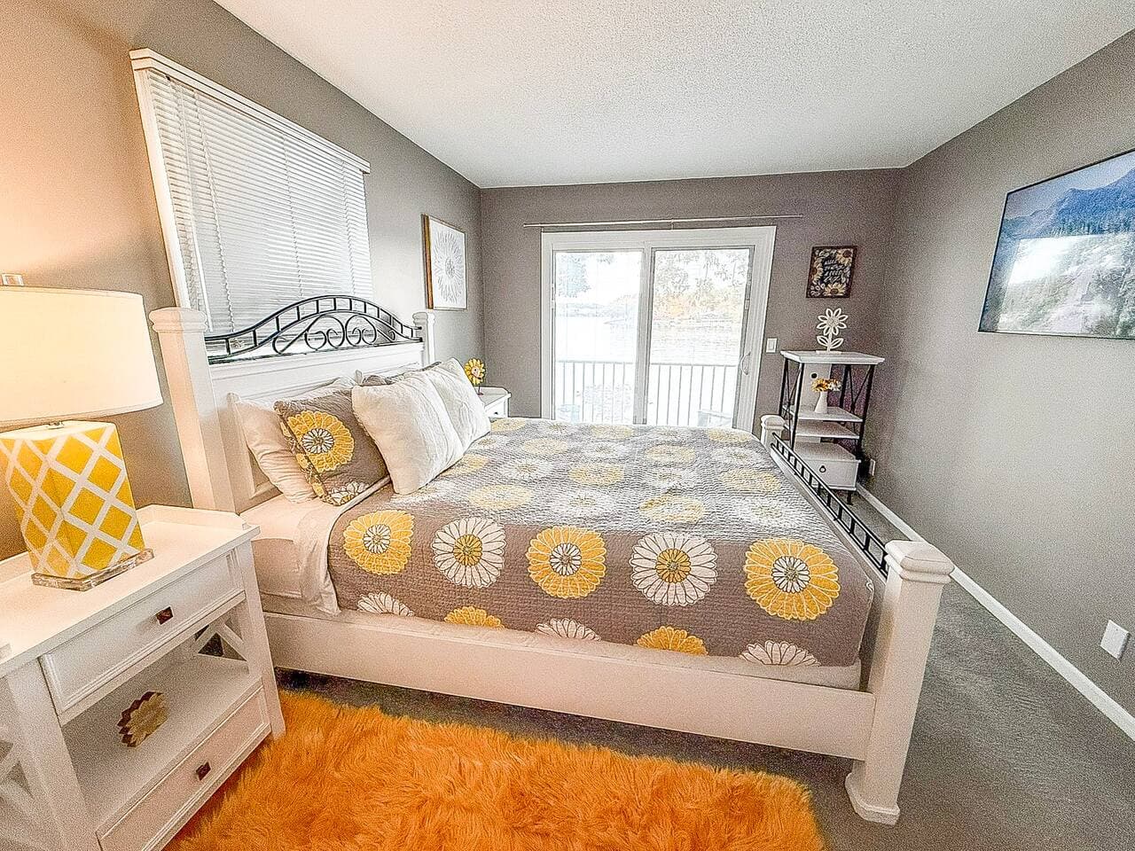 Sunny bedroom with vibrant rug and patio doors.