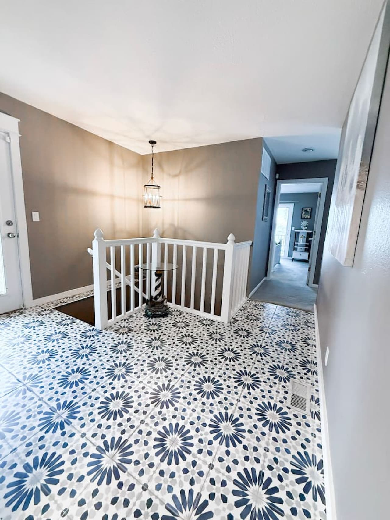 Charming landing with patterned tile and modern light fixture.
