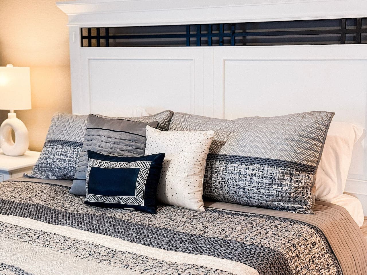 Cozy bed with stylish layered pillows.