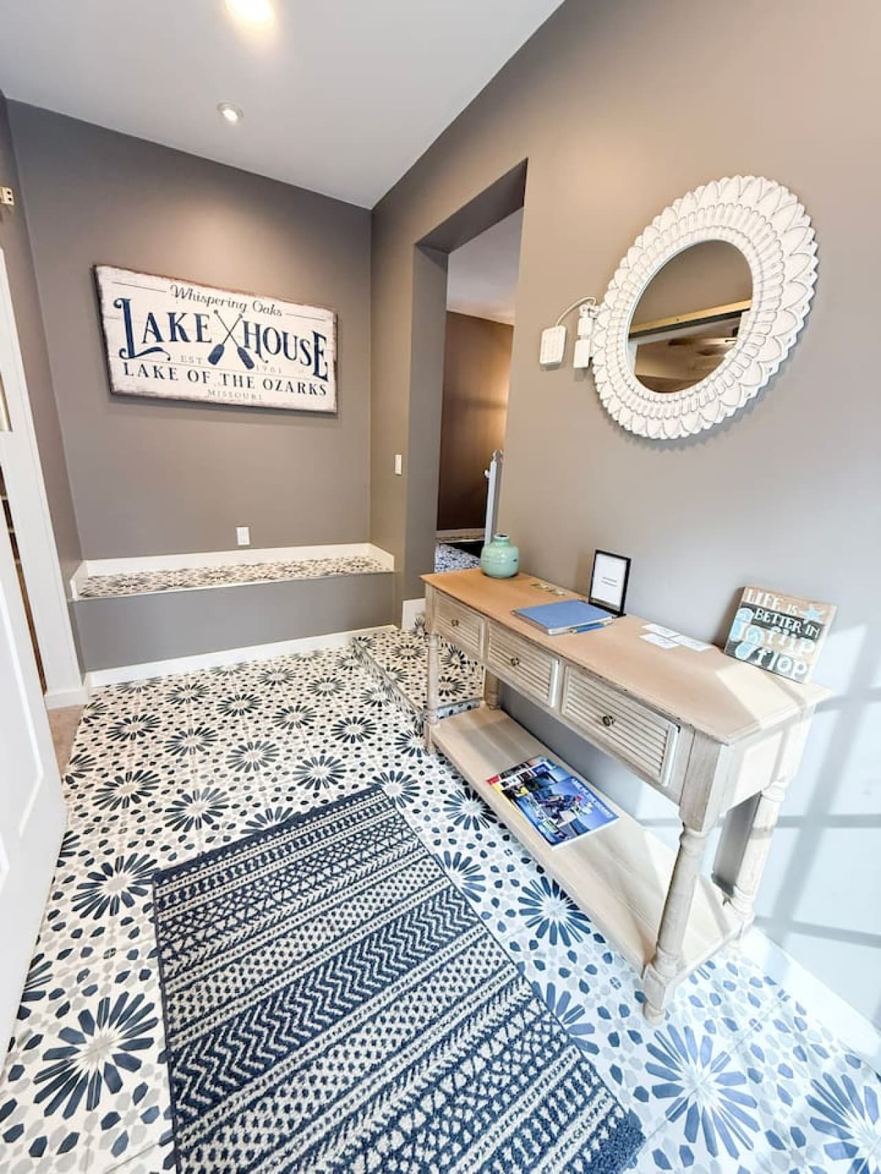 Welcoming entryway with unique tiled flooring and lake house sign.