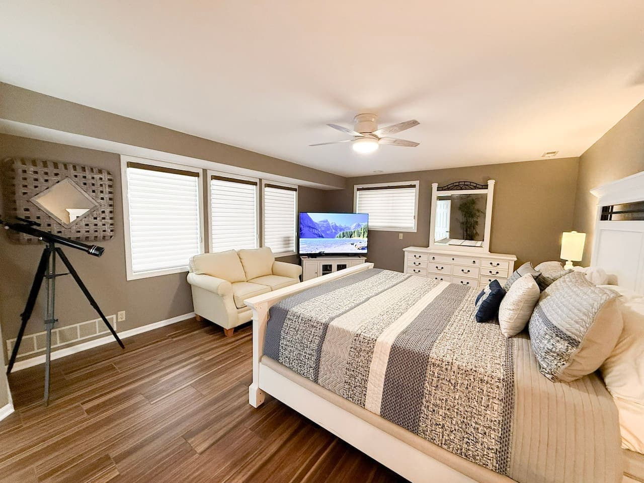 Spacious master bedroom with a comfortable seating area and TV.