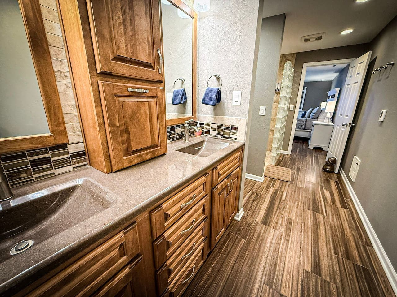 Spacious bathroom with a double vanity and sleek wooden floors.