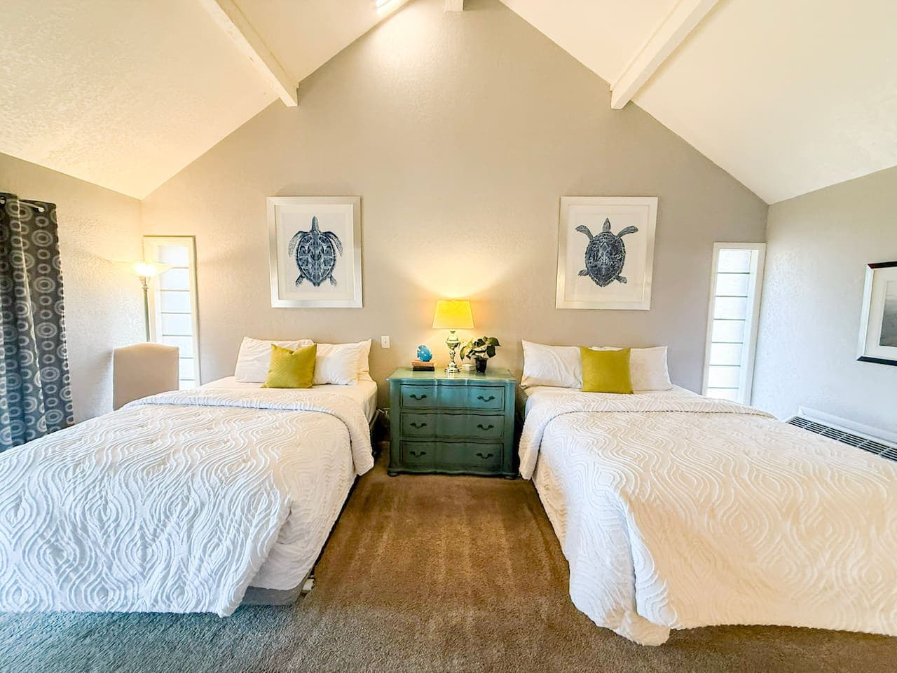 Relax in a bright, spacious bedroom with comfortable beds and calming coastal décor for restful nights.