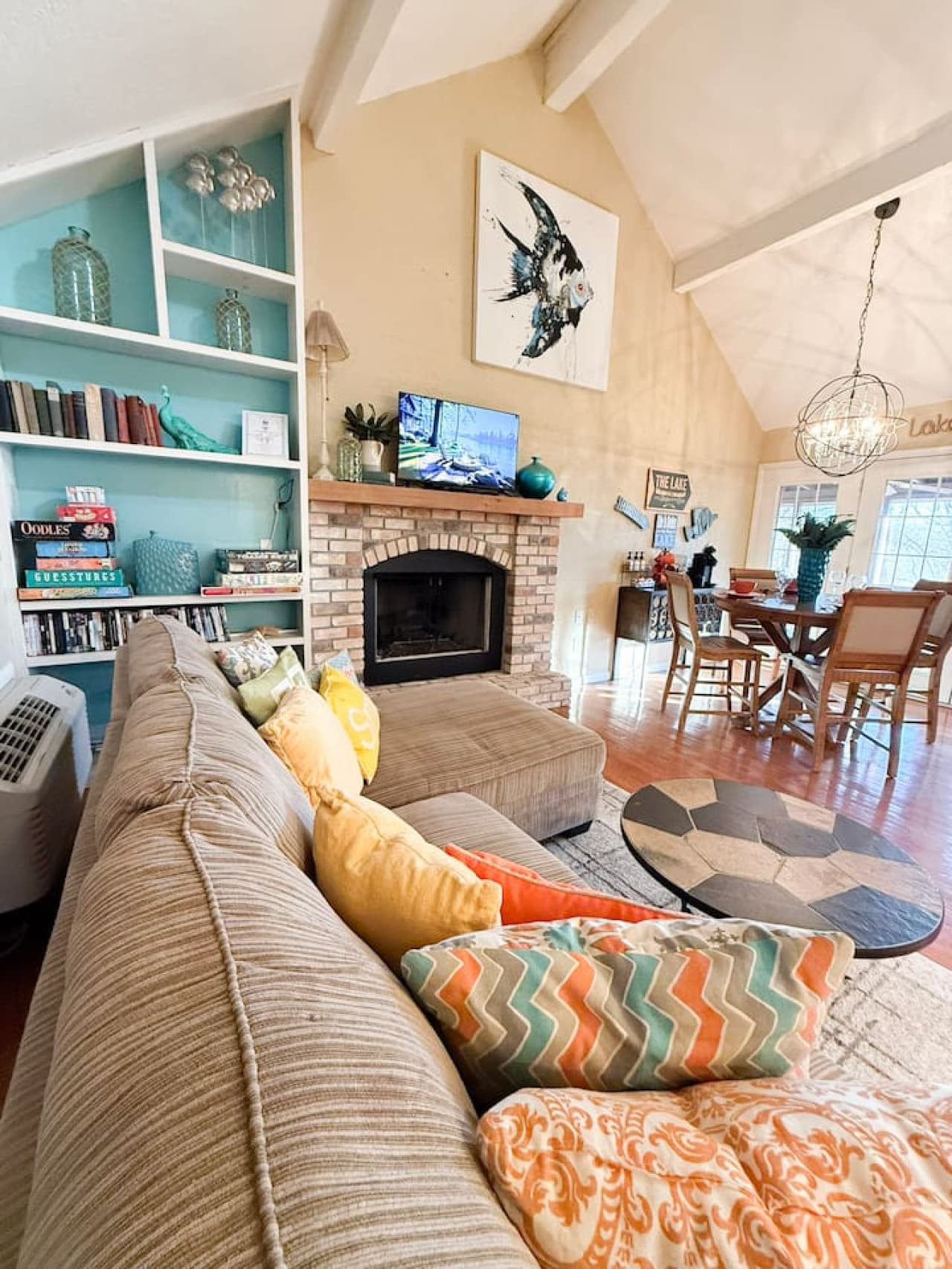 Relax in a bright, open-concept living space with cozy seating, a charming fireplace, and stylish lake-inspired décor.