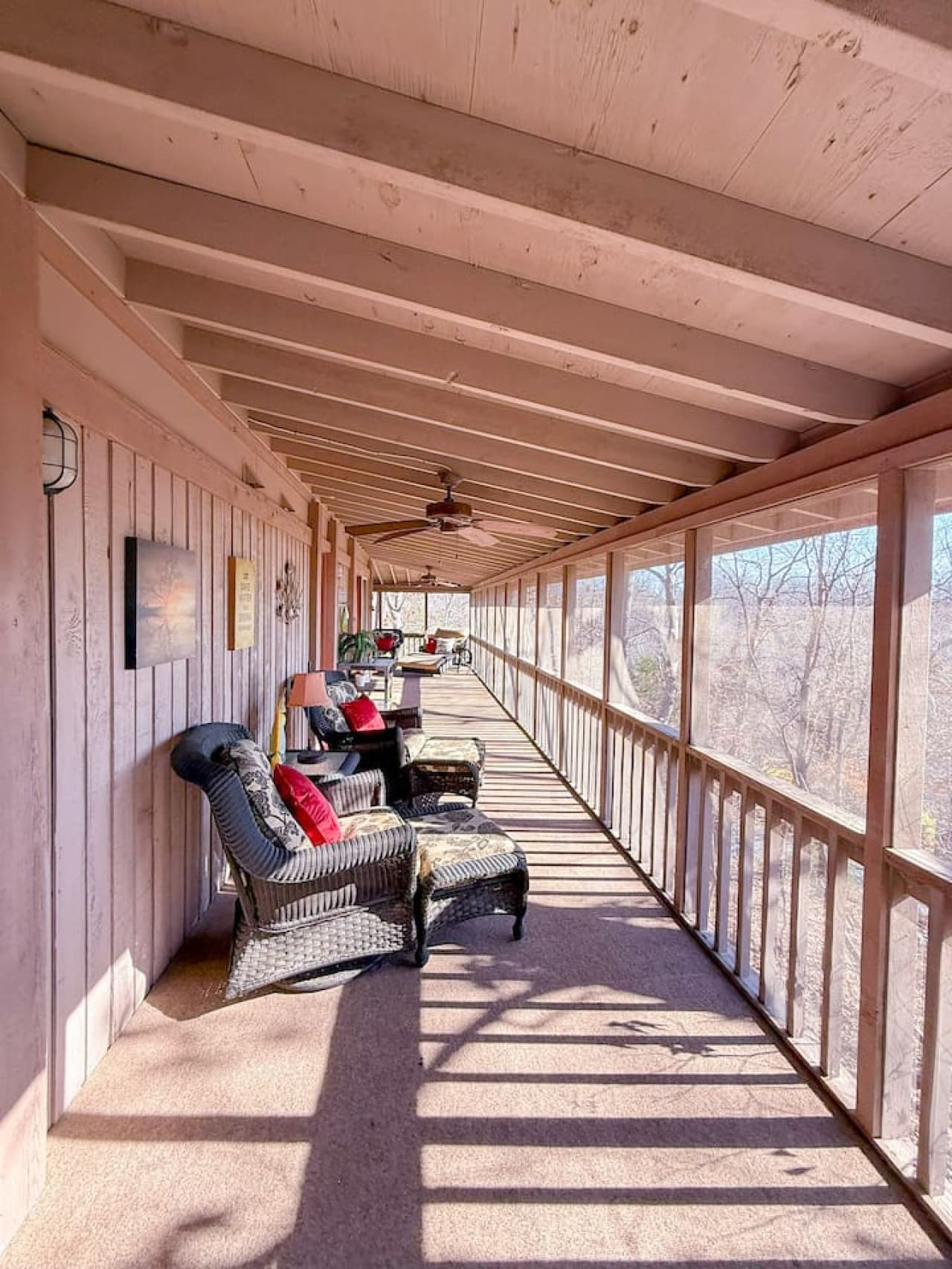 Relax on the spacious screened-in porch with cozy seating and peaceful wooded views.
