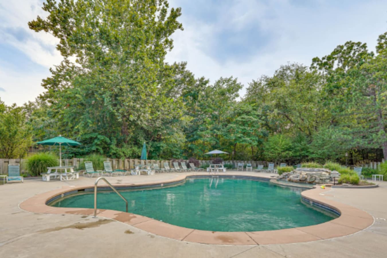 Cool off in a beautiful outdoor pool surrounded by trees—perfect for sunny days and relaxing afternoons.