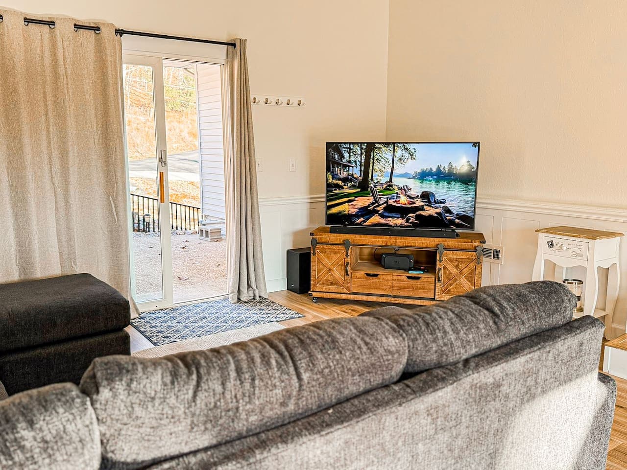 Relax in this cozy lakefront living space with TV and direct deck access, perfect for unwinding after a day on the water.