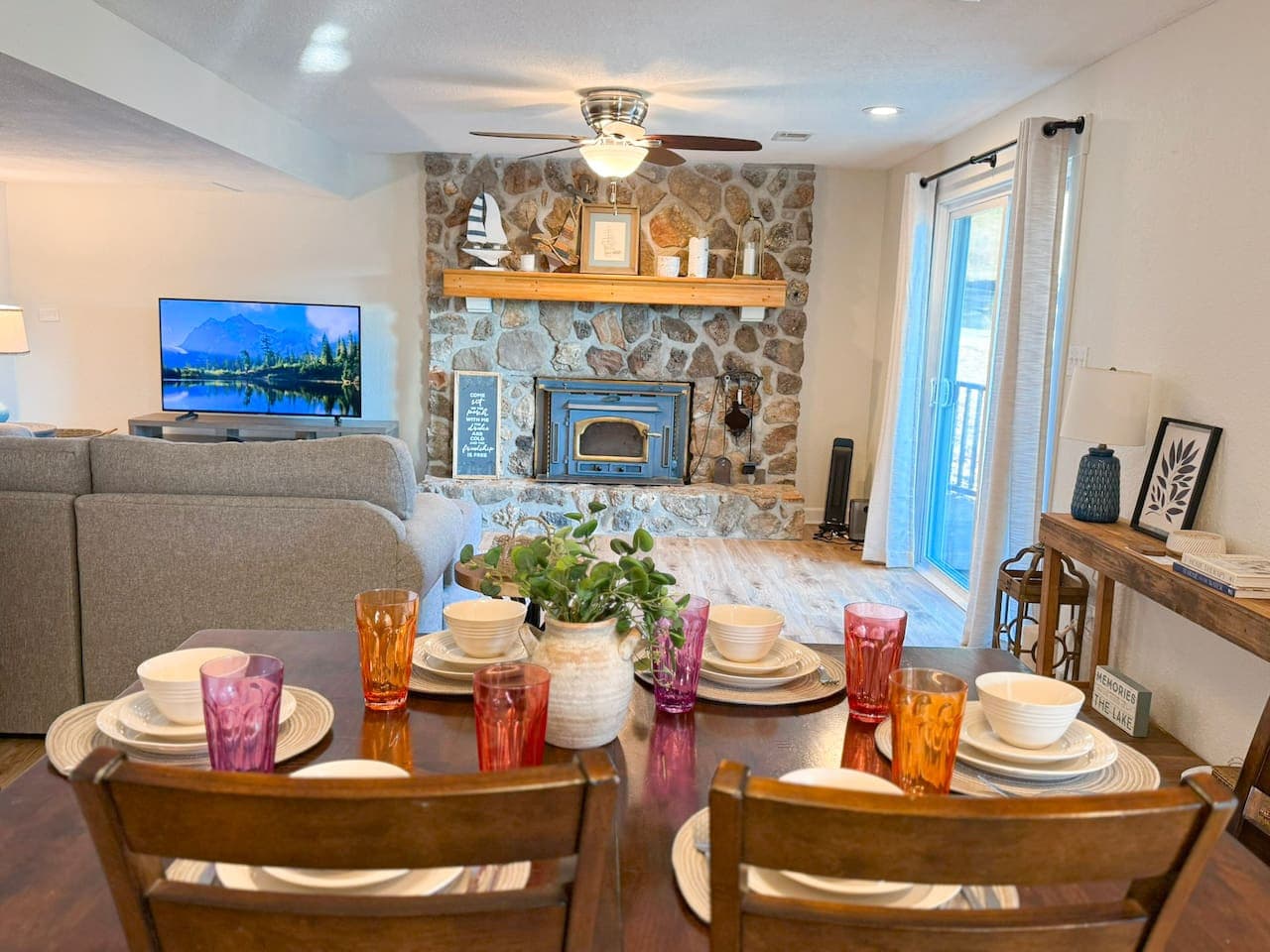 Gather and unwind in this warm, lake-inspired living space with a cozy stone fireplace and inviting dining area.