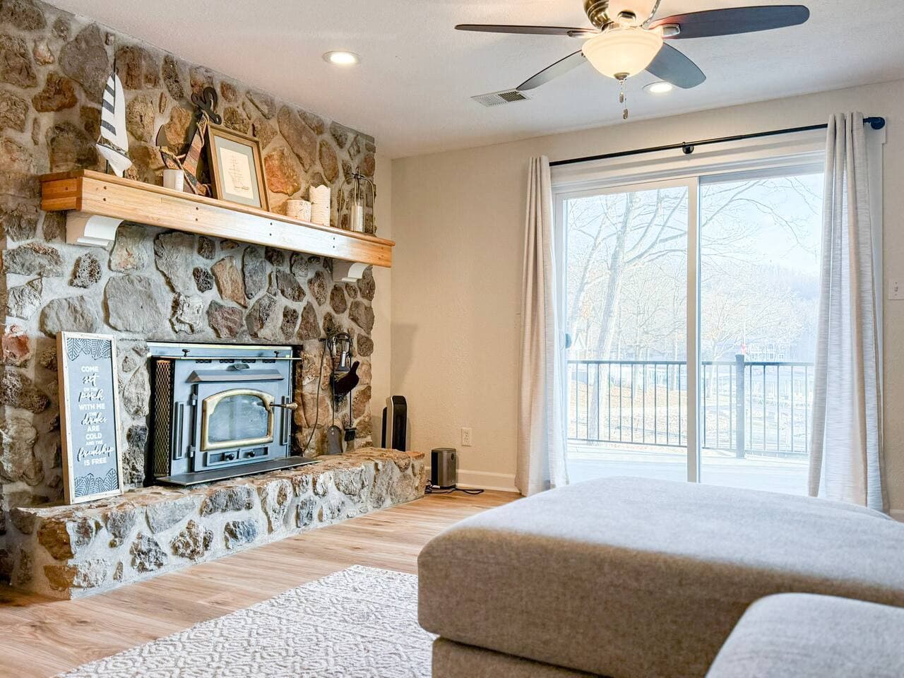 Relax in this cozy lakefront living space with a stunning stone fireplace, perfect for unwinding after a day on the water.