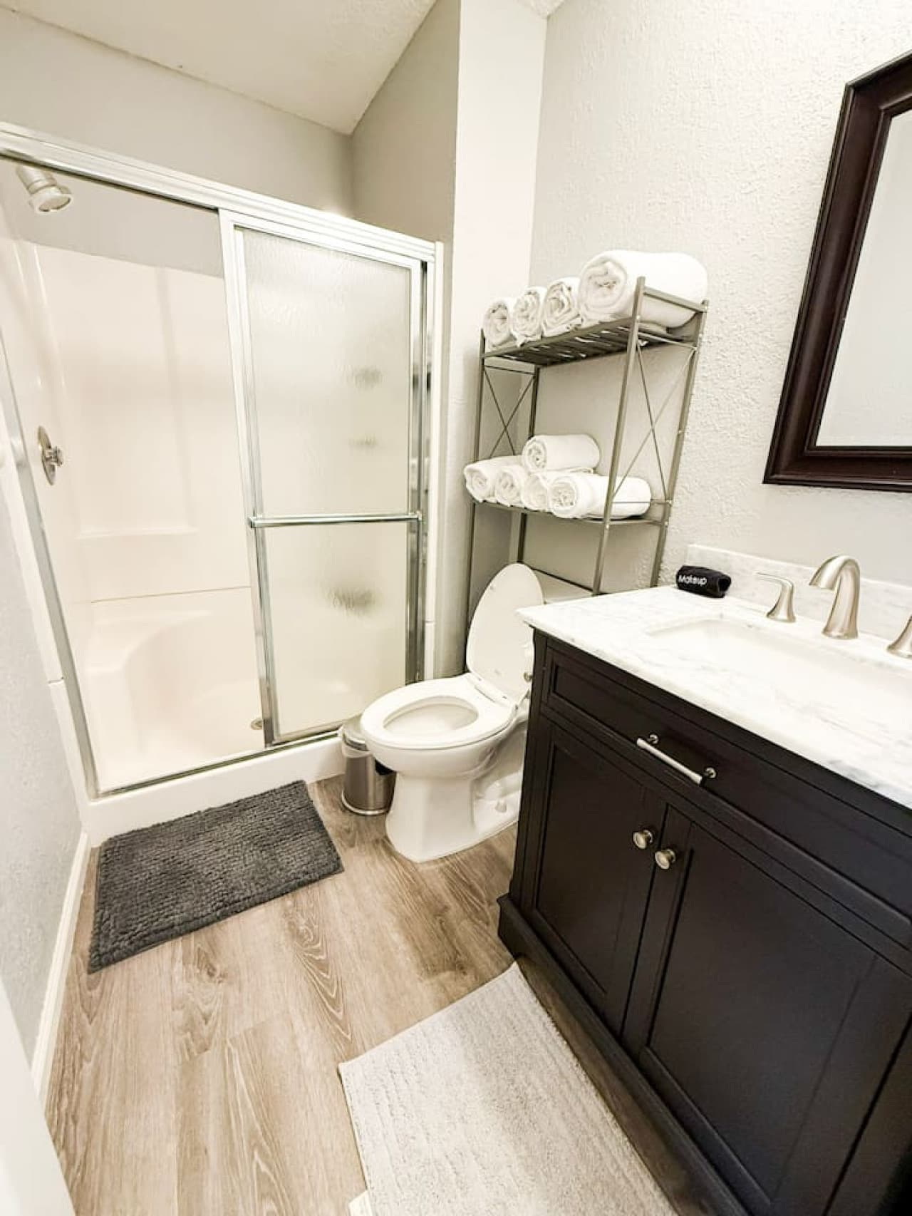 Refresh in a clean, modern bathroom with a walk-in shower and fresh towels, designed for comfort and convenience.