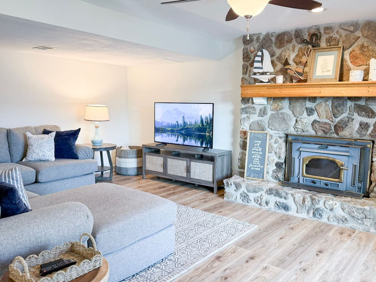 Gather and relax in the cozy living room with stone fireplace and TV, perfect after a day on the lake.