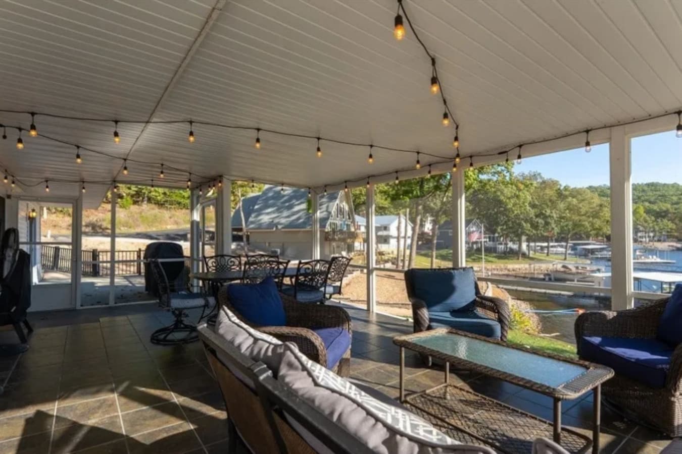 Unwind on the covered outdoor lounge with string lights, perfect for evening relaxation and lake-area gatherings.