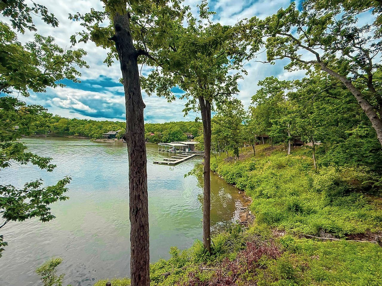 Immerse yourself in the serene beauty of the lake, framed by lush trees, from the vantage point of Treetop Village. Your perfect lakeside escape awaits.