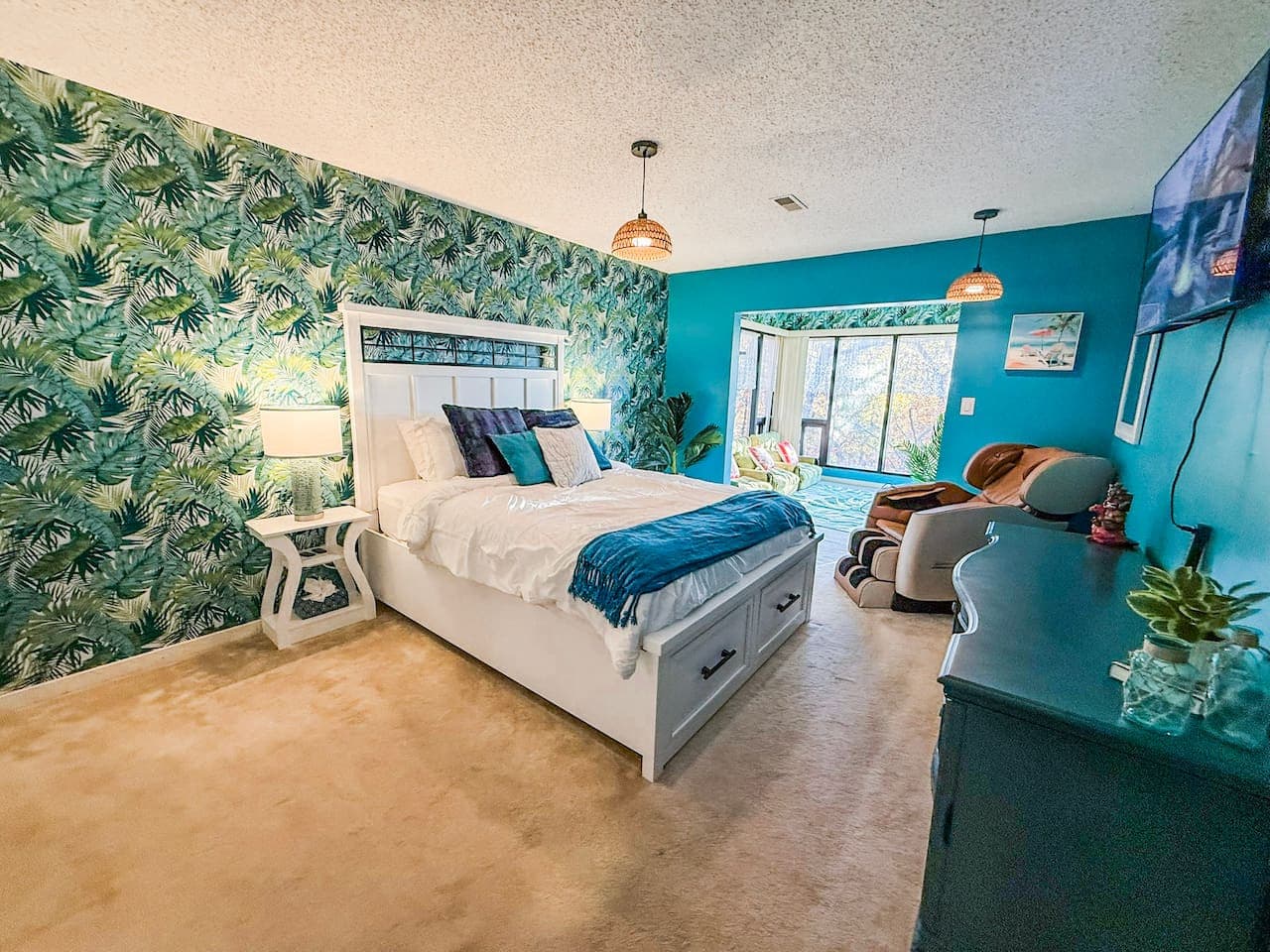 Bedroom view showcasing the bed, accent wall, and natural light.