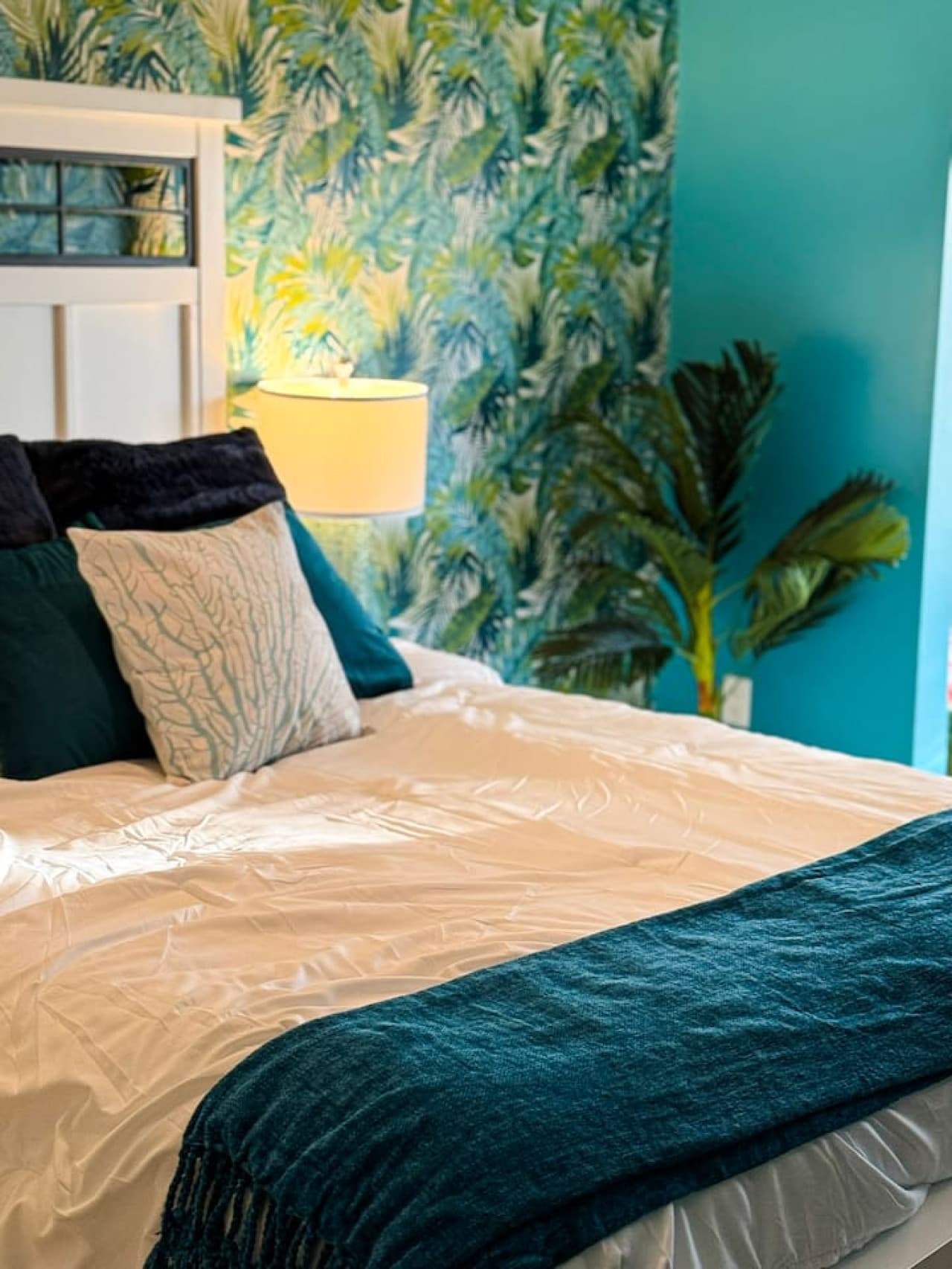 Close-up of the comfortable bed with plush pillows and tropical accents.