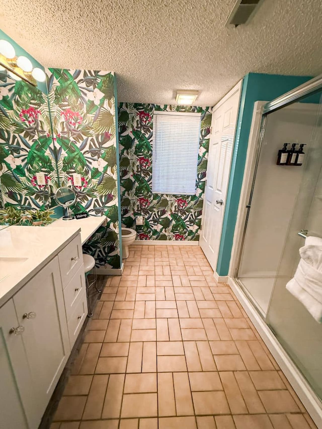 Modern bathroom with tropical wallpaper and shower.