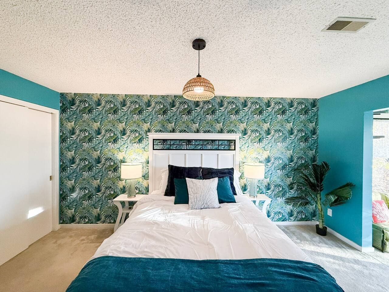 Spacious bedroom featuring a lush botanical accent wall.