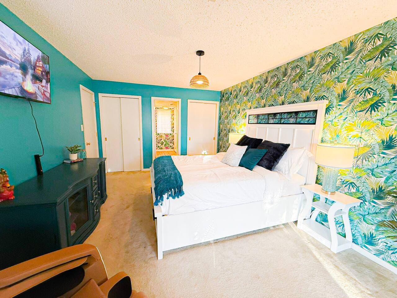 Tranquil bedroom with vibrant accent wall and cozy bedding.