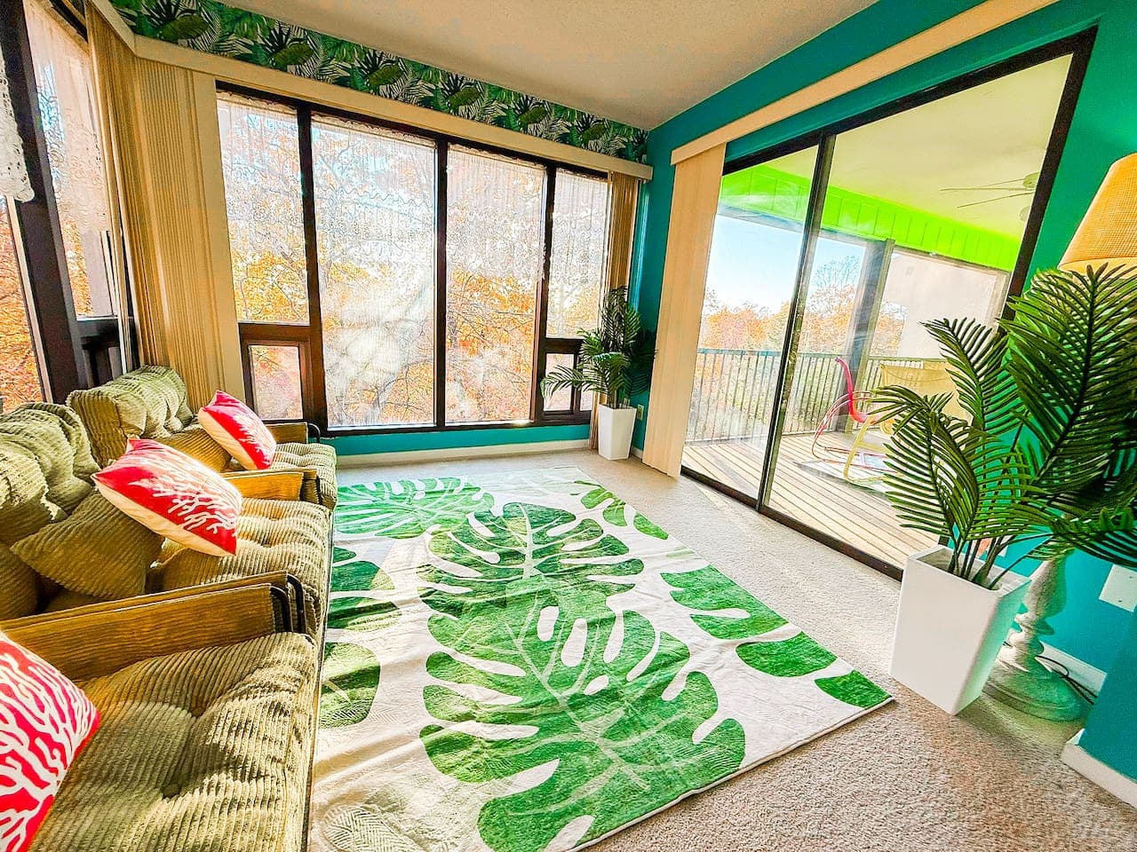 Cozy sunroom with large windows and tropical décor.