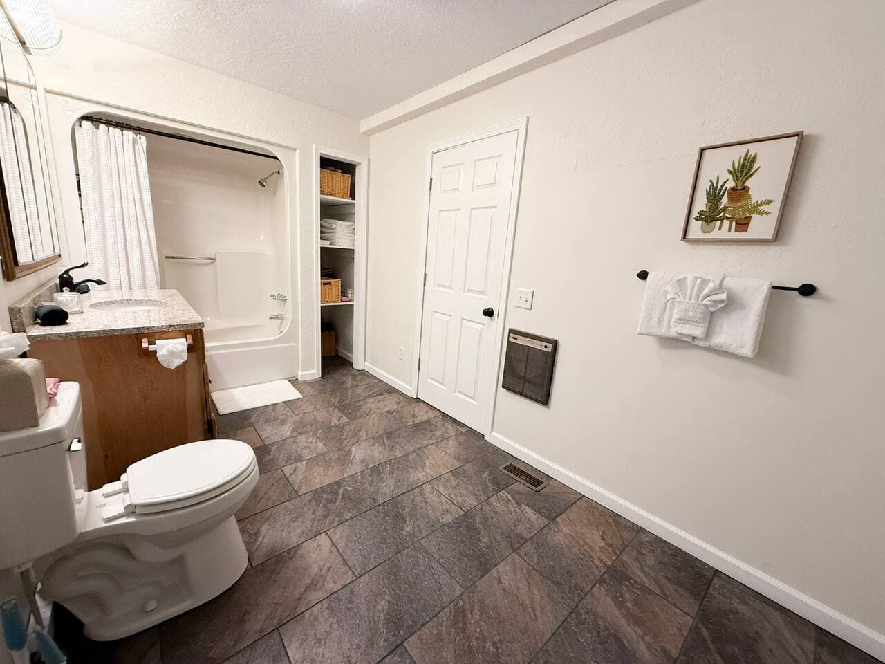 Bright and clean with a full tub, open shelving, and fresh modern touches.