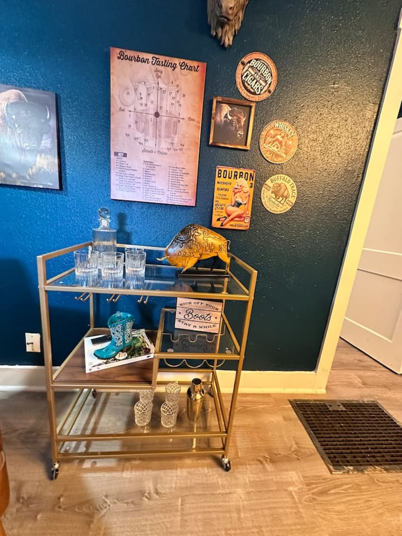 A refined Western bar cart display—buffalo art, bourbon maps, and vintage glassware set the tone for laid-back evenings.