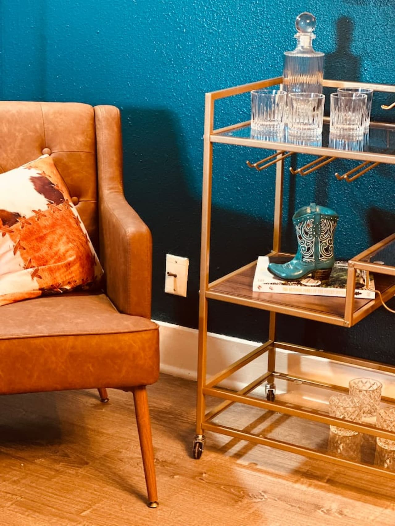 A bold corner bar cart displays vintage whiskey signs and western charm.