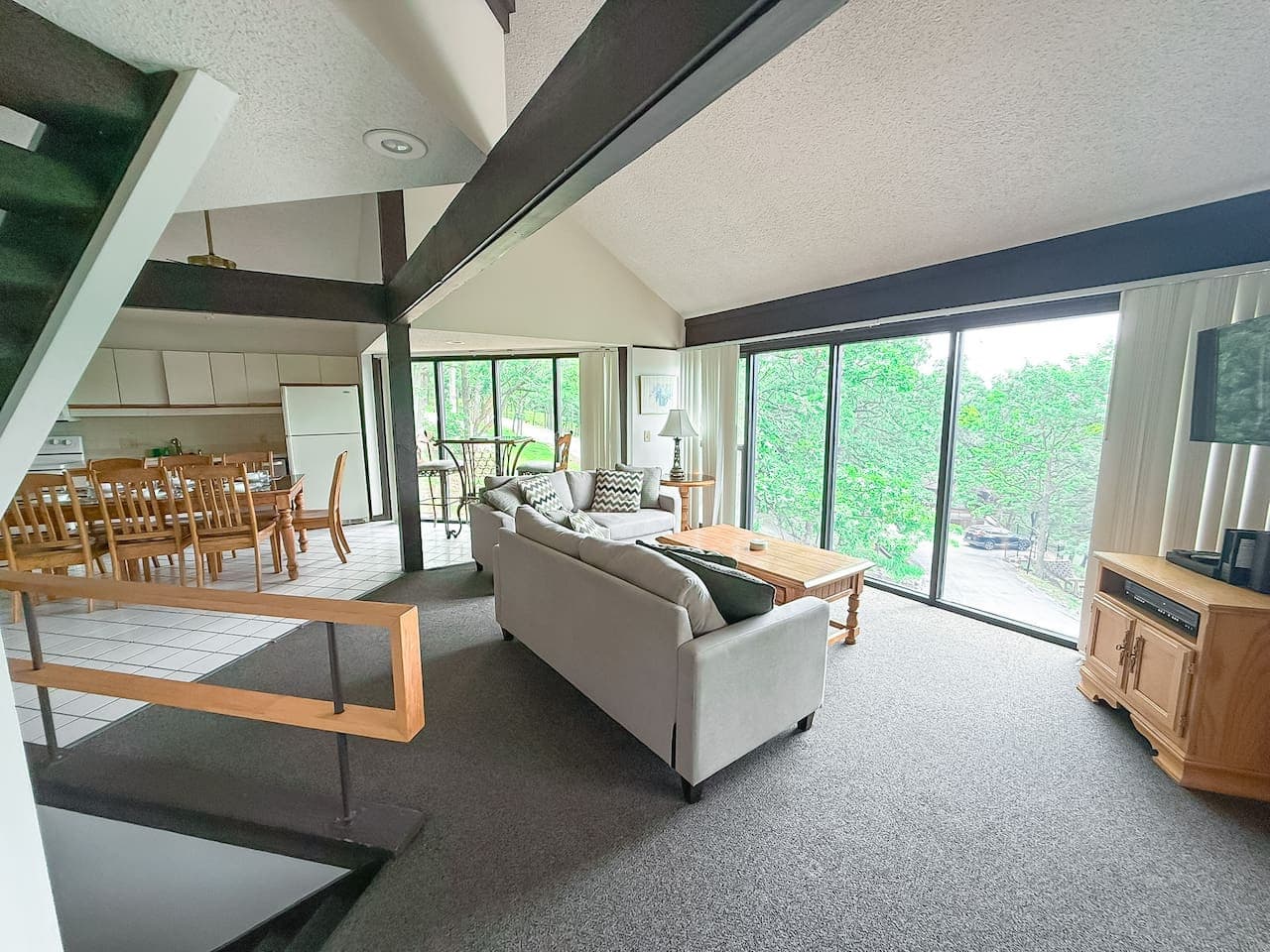 "Relax and unwind in our spacious living room, where large windows bring the beauty of the outdoors inside. Plenty of room for everyone to gather!"