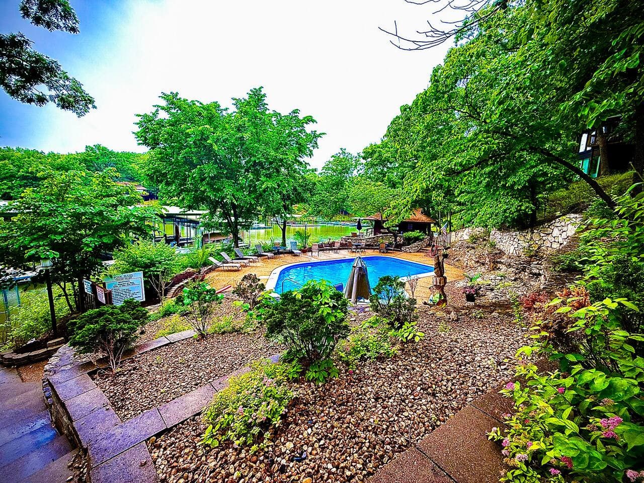 "Dive into relaxation at our inviting outdoor pool! Surrounded by lush greenery, it's the perfect spot to cool off and soak up the sun."