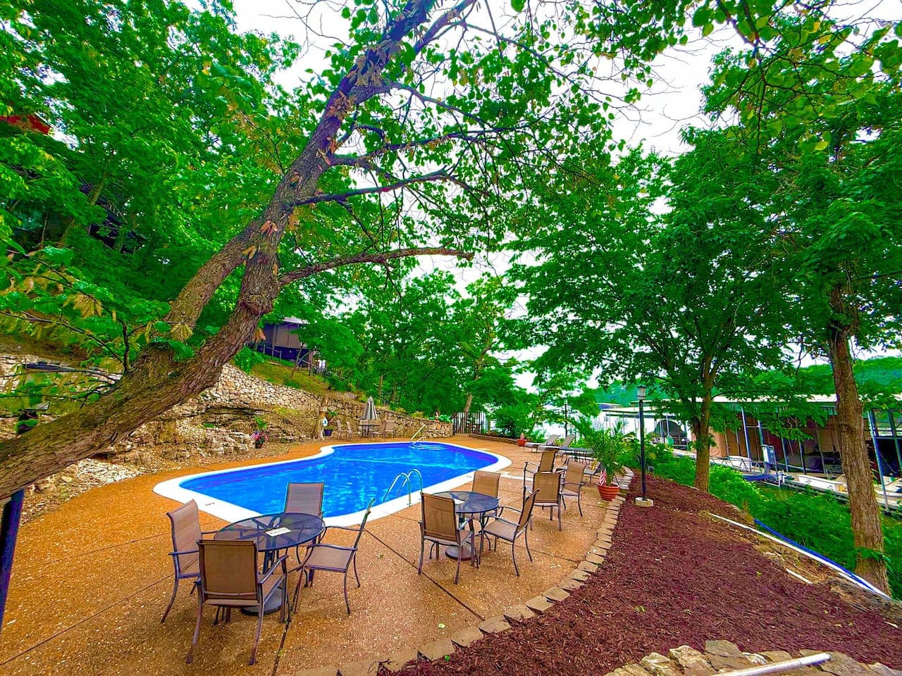 "Enjoy refreshing dips in our inviting outdoor pool, boasting stunning lake views and surrounded by lush greenery. Your perfect oasis awaits!"