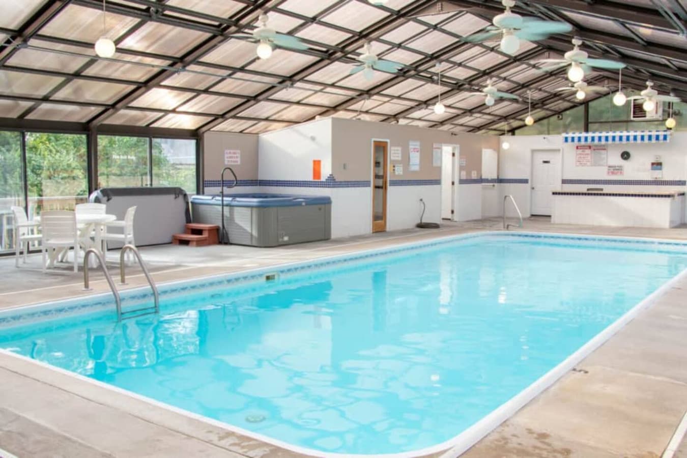 This rental boasts a fantastic indoor pool area, complete with a large swimming pool and a relaxing hot tub for year-round enjoyment. The bright and spacious enclosure, featuring numerous windows and ceiling fans, creates an inviting atmosphere perfe