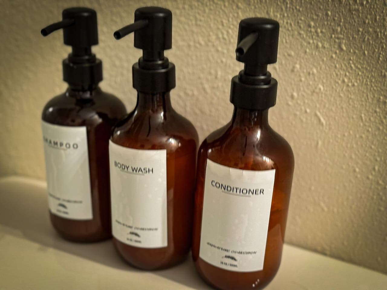 These chic, refillable dispensers offer a touch of sophisticated luxury, elevating the bathroom's aesthetic with their minimalist design. They exemplify a commitment to high-end finishes and thoughtful details, enhancing the overall spa-like feel of