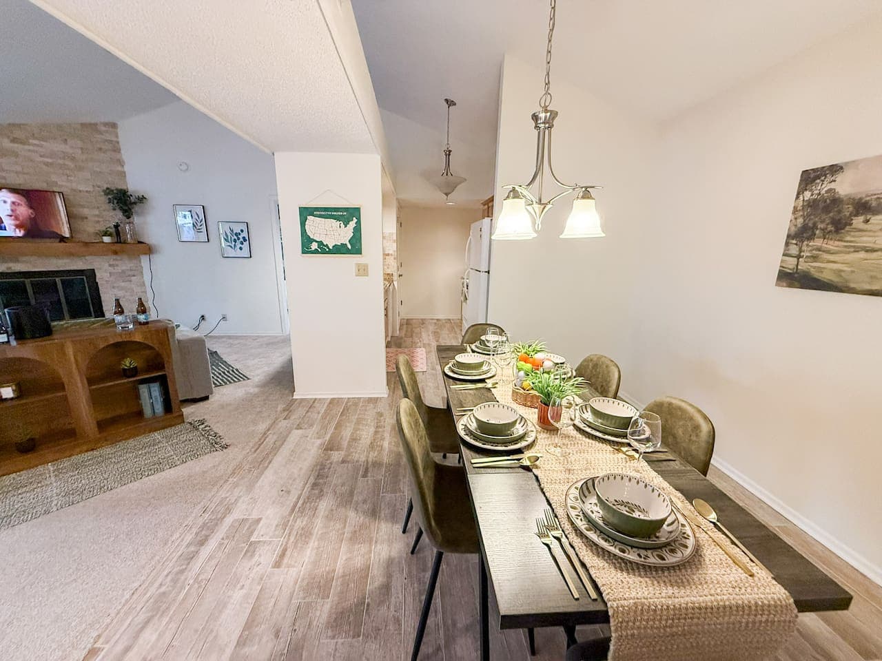 This inviting open-concept space features a well-appointed dining area with ample seating, flowing seamlessly into a cozy living room, perfect for entertaining. Enjoy the bright and airy feel, complemented by attractive wood-look flooring and a charm