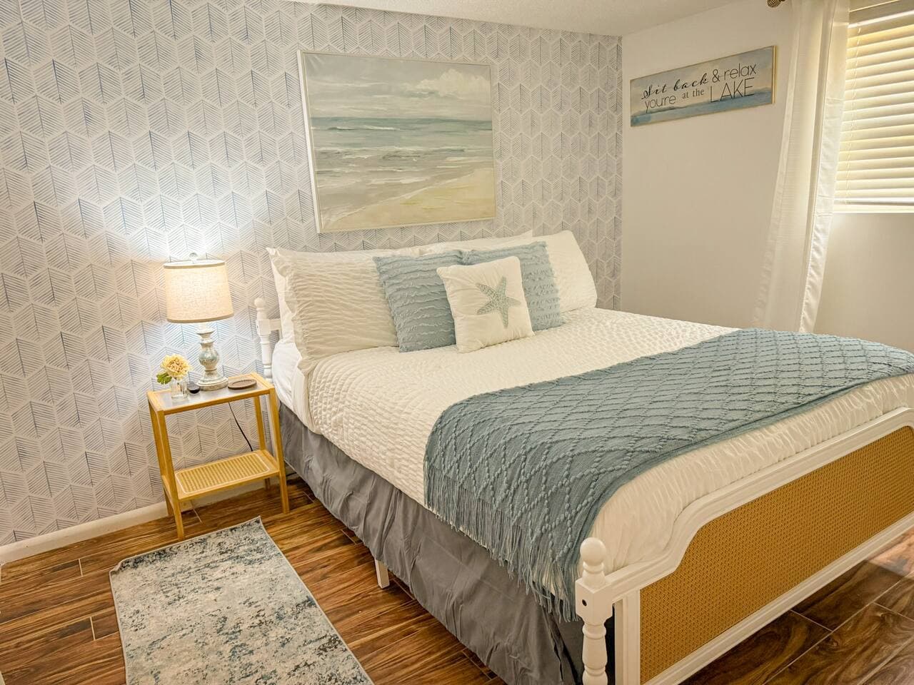 A bedroom that feels like a mystical water paradise, a queen bed wrapped in soft hues and ocean-inspired charm.