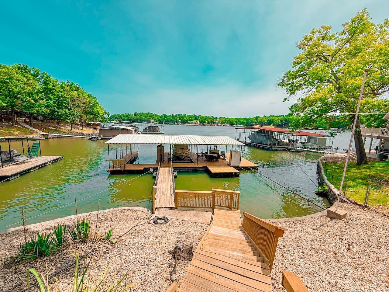 Wooden walkway gently guides you toward the water’s edge, inviting effortless access to the tranquil lake. Nestled at the end, a covered boat dock offers both protection and convenience for your watercraft.