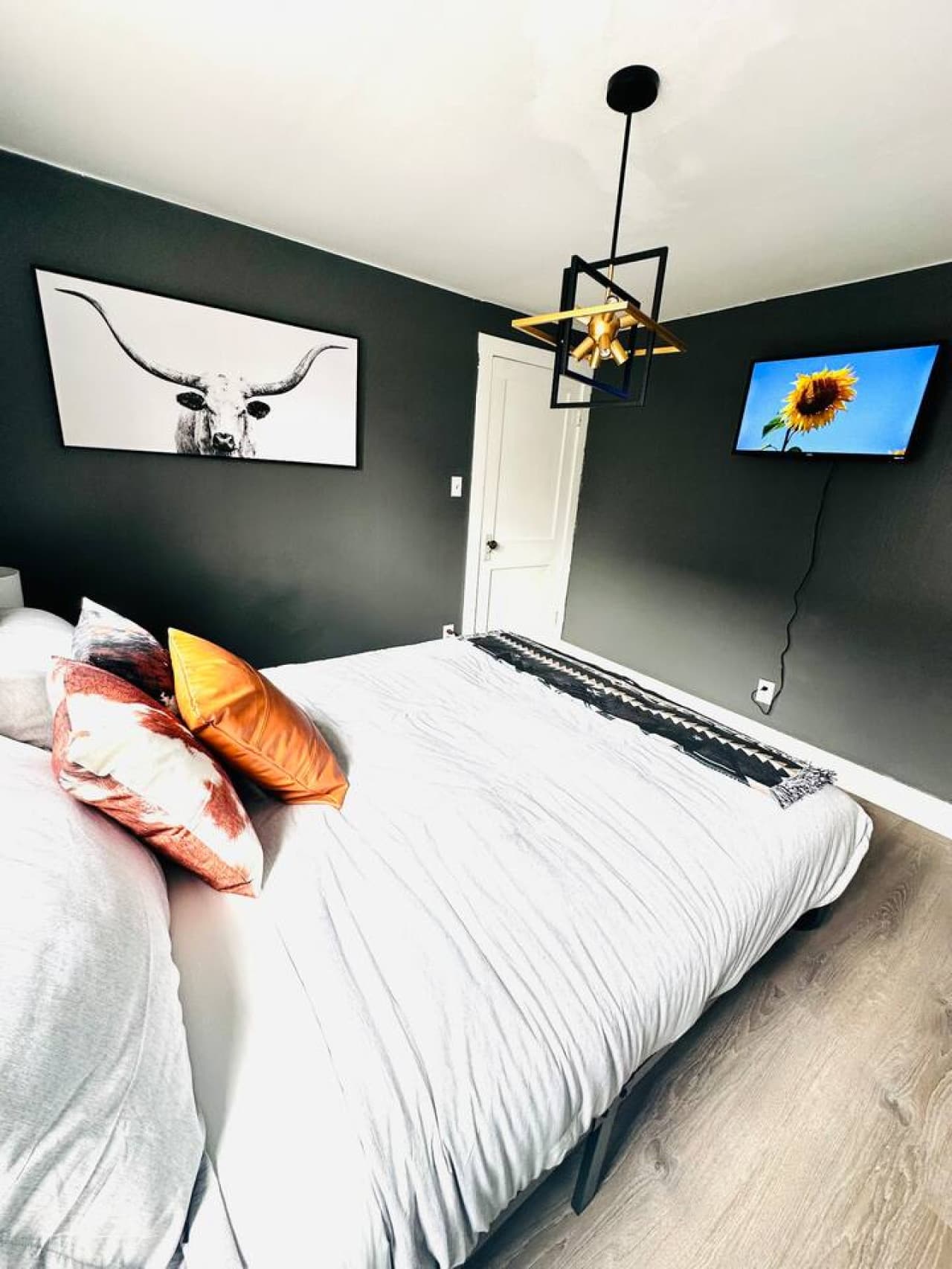 Simple and comfortable queen bedroom with a mounted TV for winding down at the end of the day.
