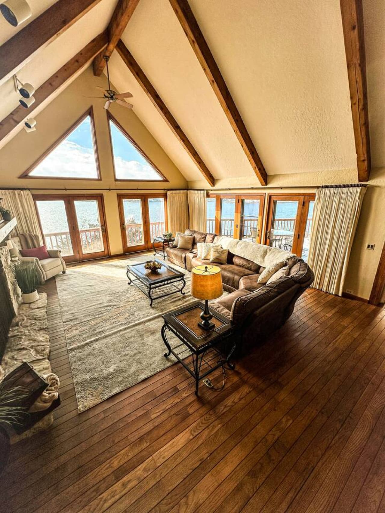 Spacious living room with floor-to-ceiling windows offering unbeatable views of the lake—perfect for sunrise or sunset.