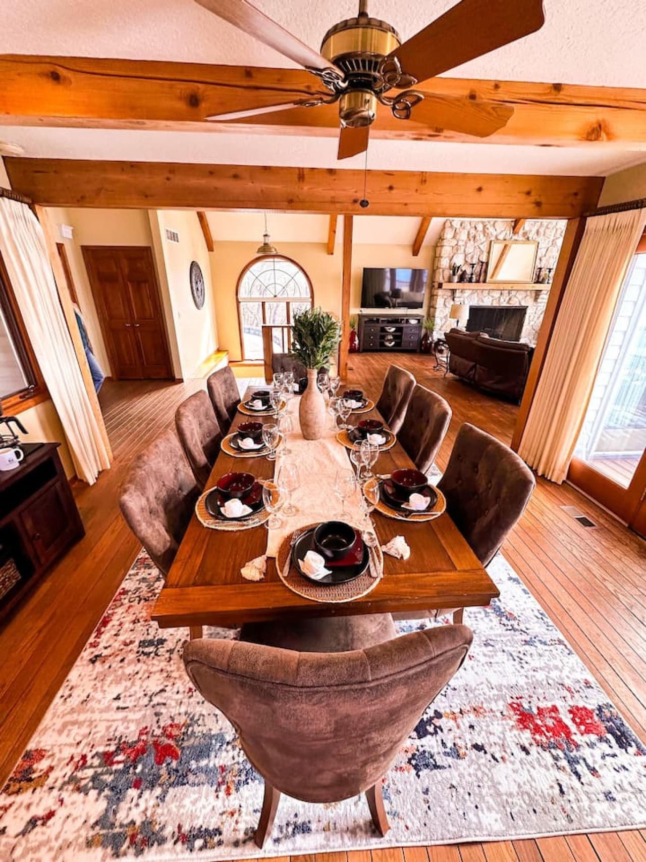 Spacious dining room featuring exposed wood beams, natural light, and a cozy ambiance perfect for any occasion.