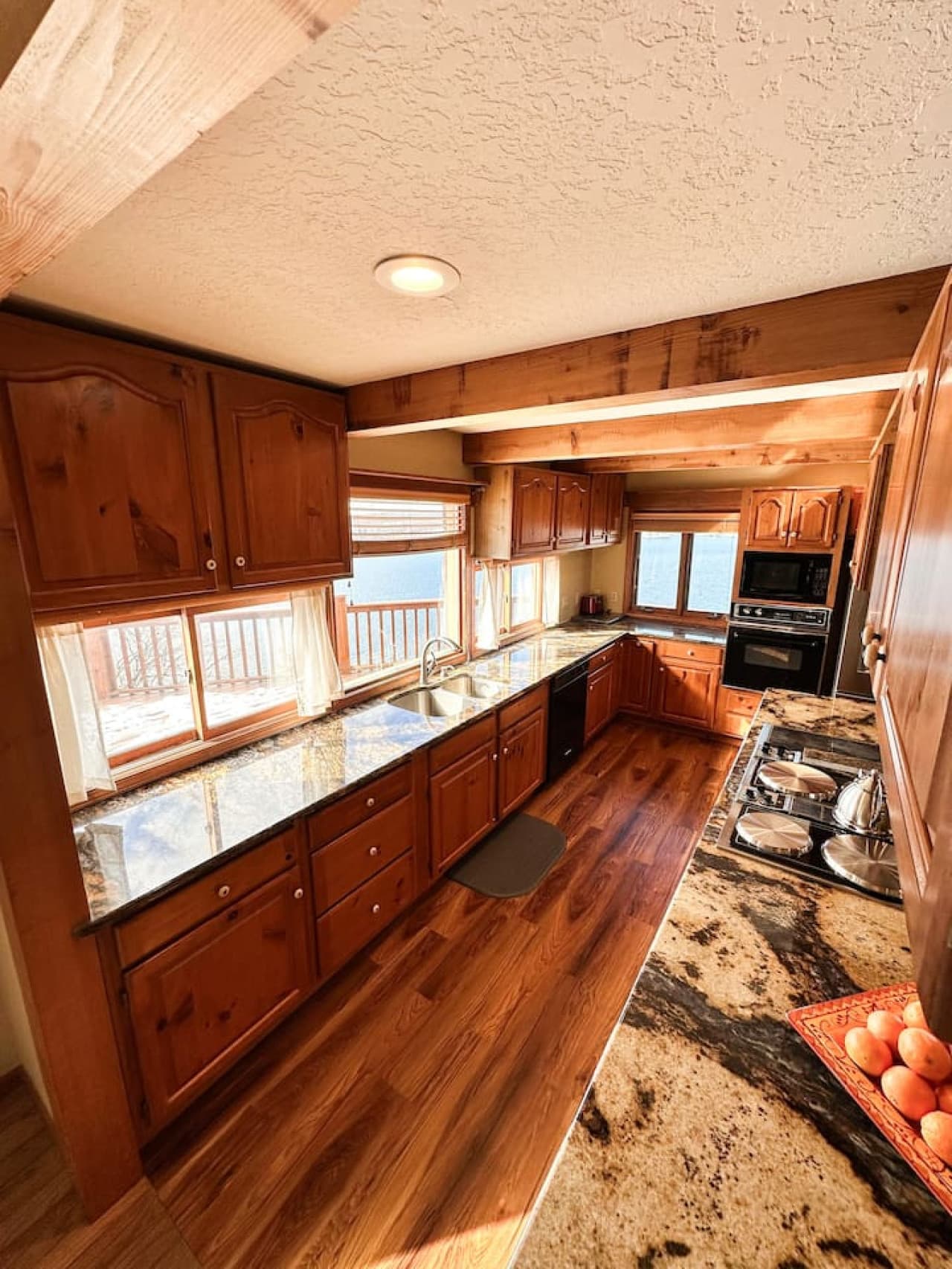 Prepare your meals with a view! Large windows bring natural light and serene lake vistas into the kitchen.