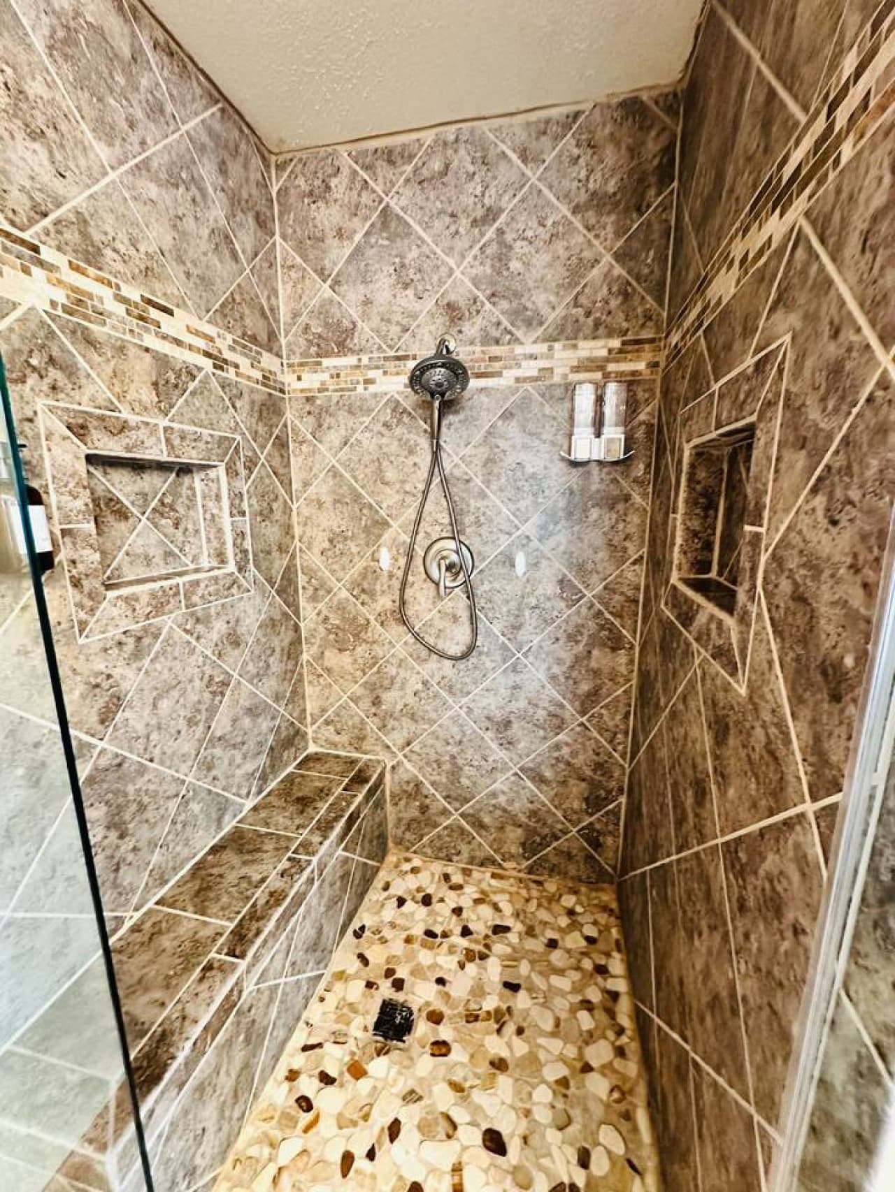 Unwind in this beautifully designed walk-in shower featuring custom tiles and premium fixtures.