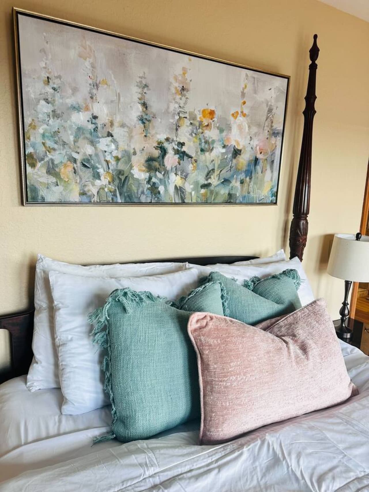 A mix of soft colors and floral artwork bring elegance and tranquility to this inviting queen bedroom.