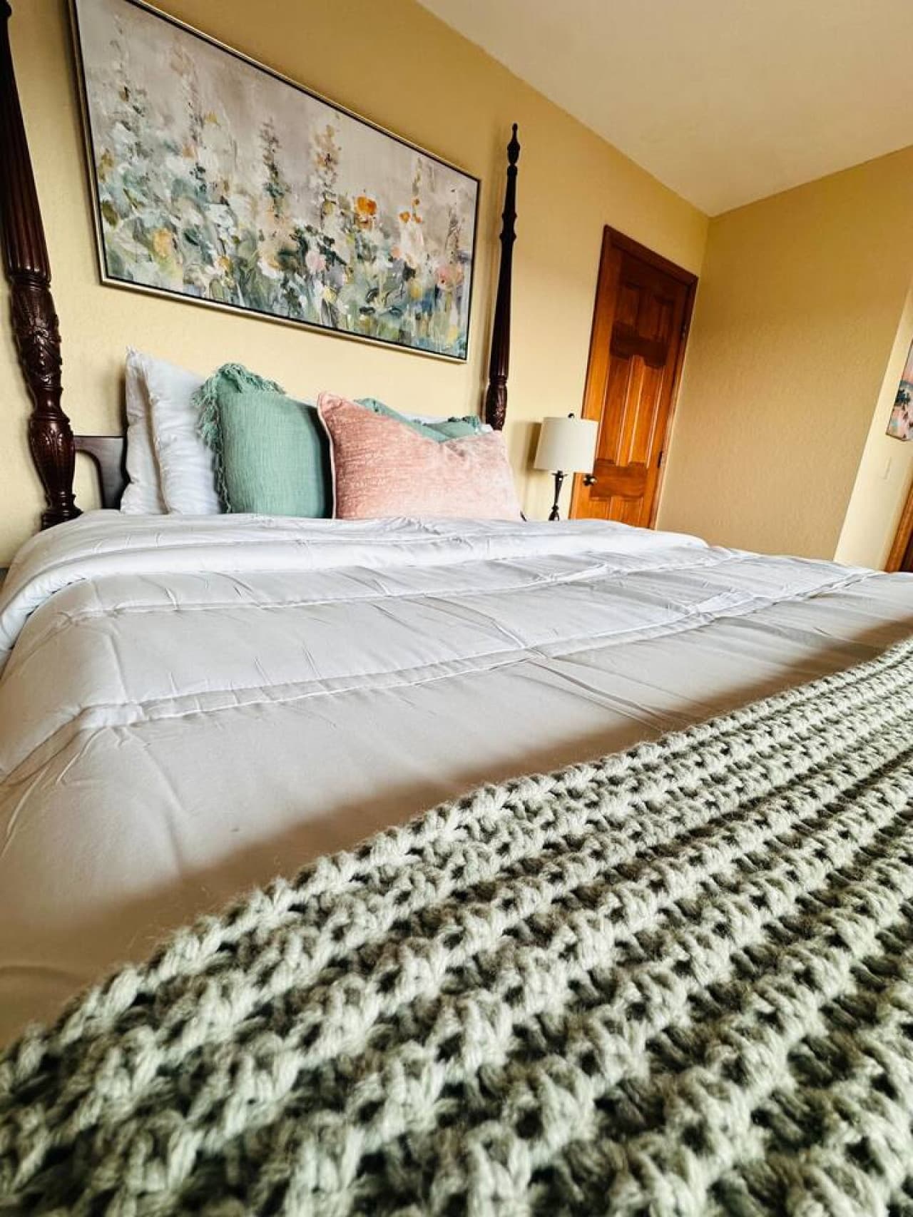 Relax in this beautifully designed queen bedroom featuring a luxurious four-poster bed and soft, inviting bedding.