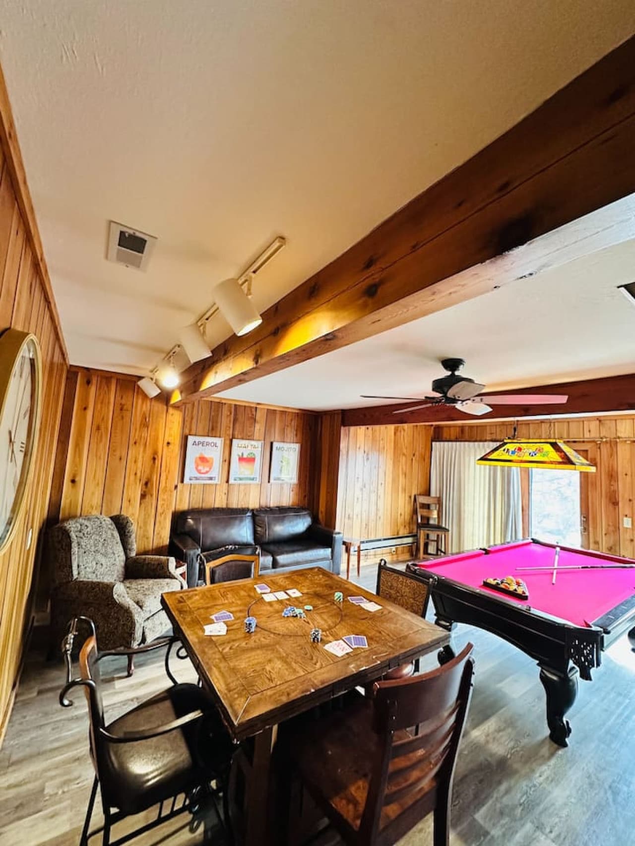 Spacious game room with a smart TV, mini fridge, and plenty of seating.