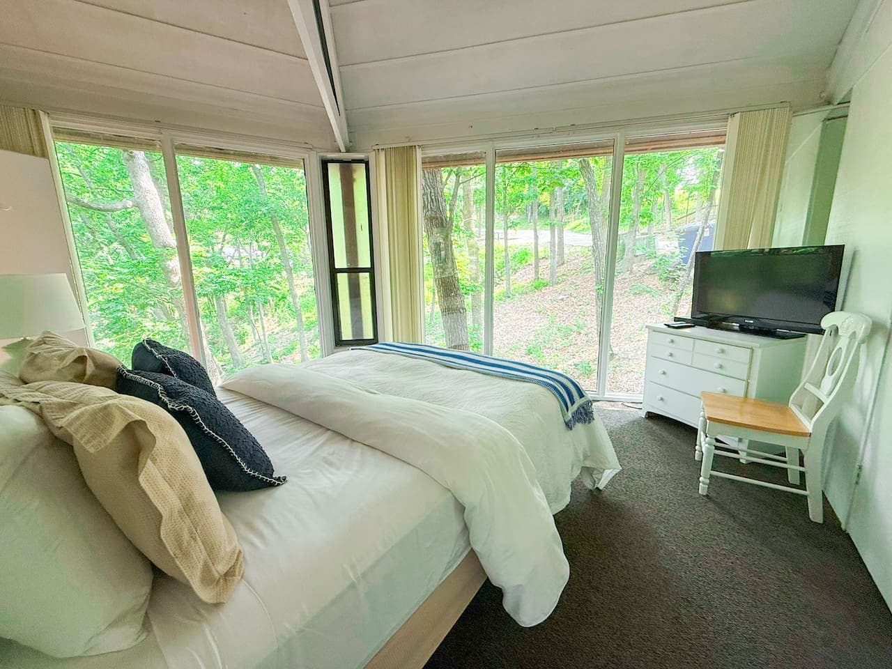 Wake up in the treetops—this serene bedroom offers beautiful forest views right outside your window.