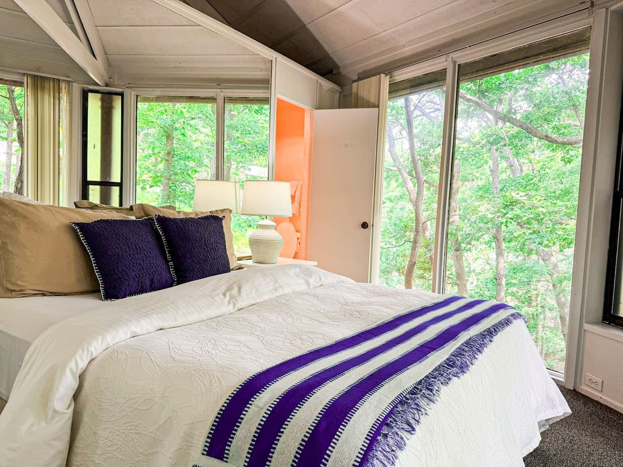 Let the morning light and forest views greet you—this cozy bedroom blends comfort with nature.