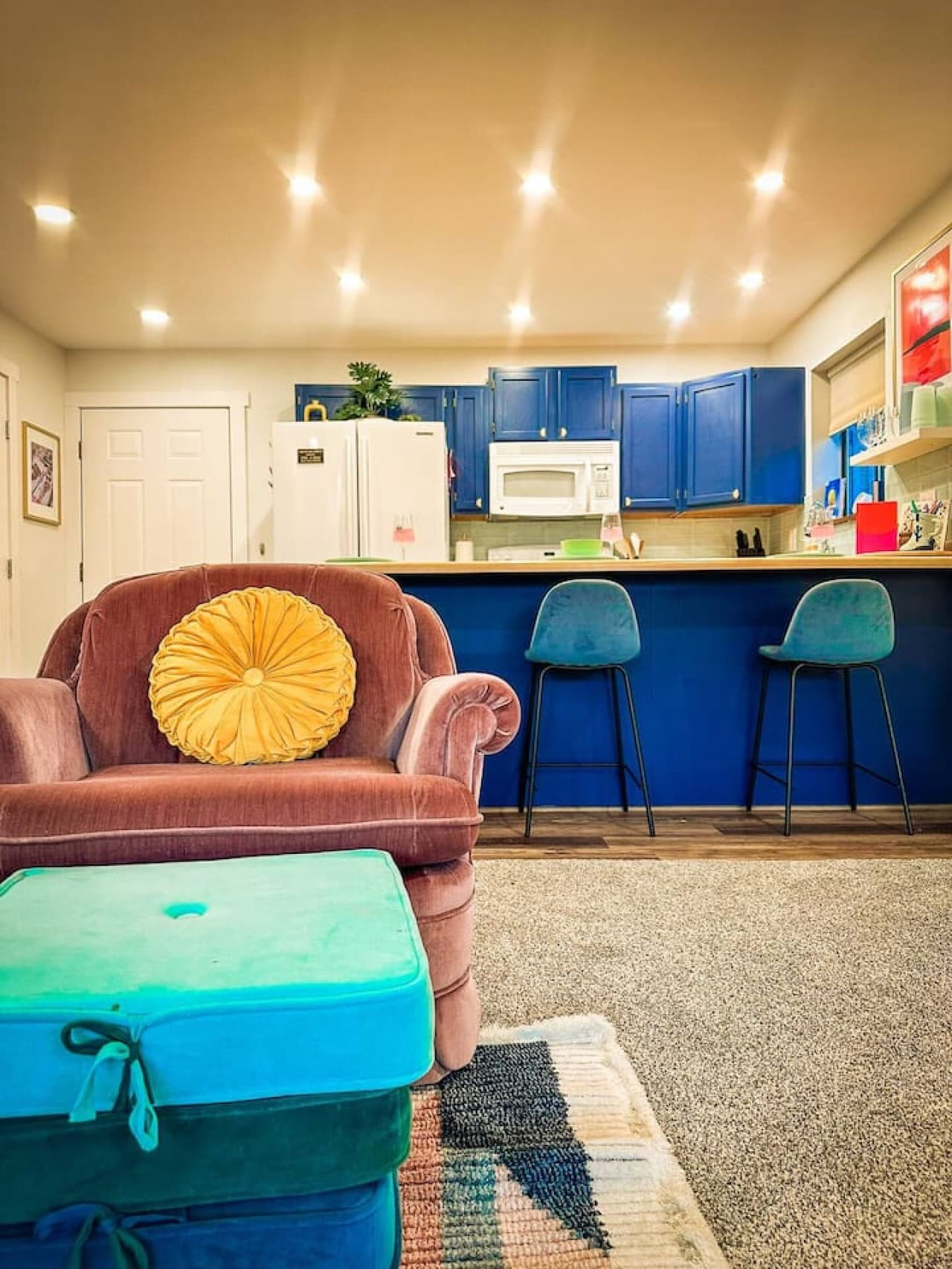 Relax in the inviting living room, complete with vibrant decor and a direct view of the fully equipped kitchen.