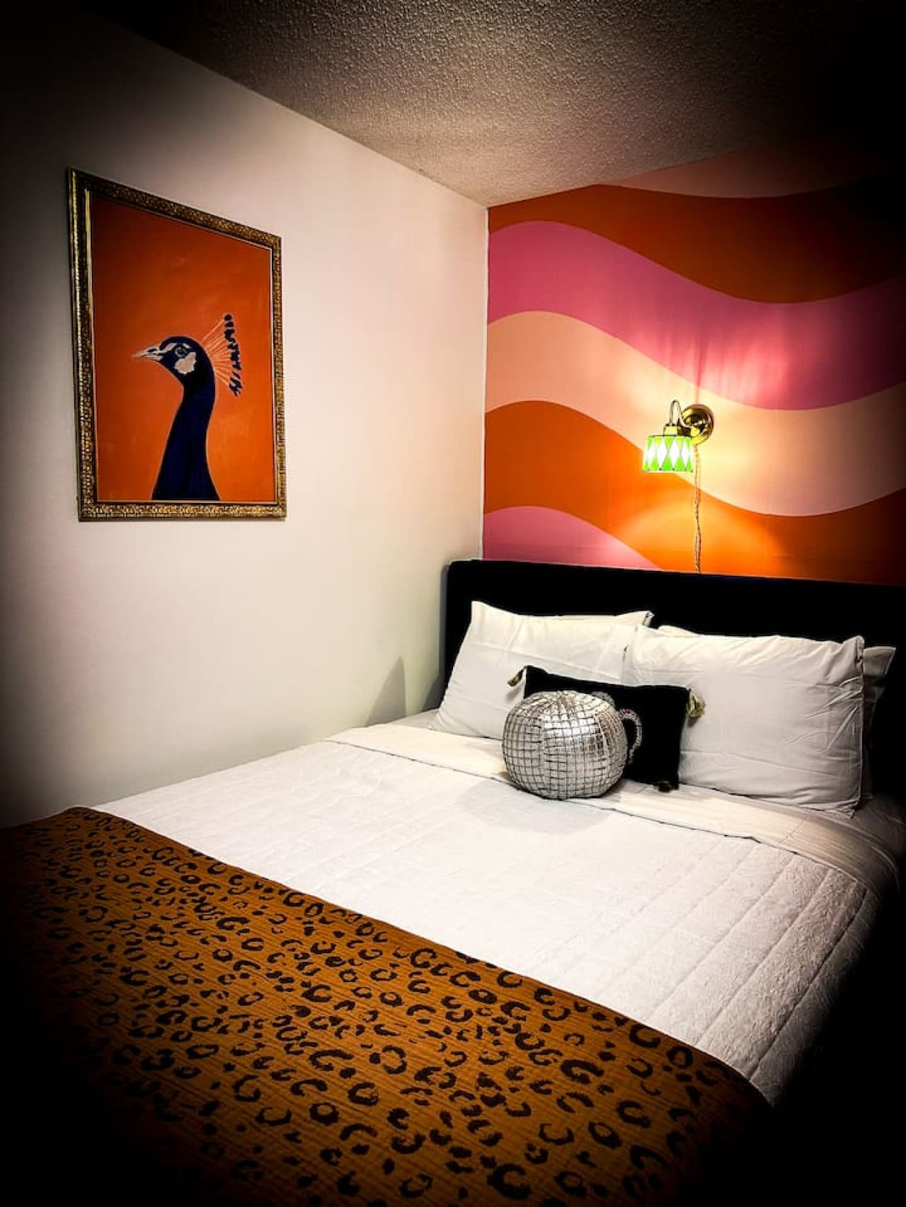 Charming queen bed touches and vibrant art create a cozy retreat you'll never want to leave.