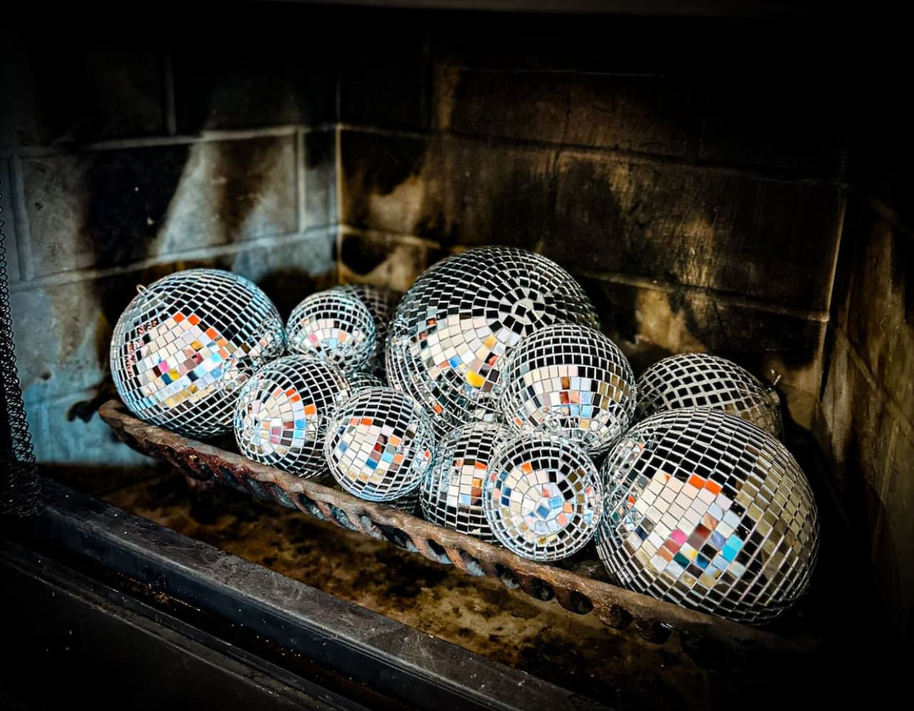 A unique feature with shimmering disco balls in the fireplace adds a playful charm to the living area.
